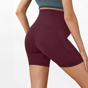 Detail of burgundy high-waisted maternity yoga shorts featuring side phone pockets