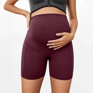 Close-up view of burgundy high-waisted maternity sports shorts with belly support