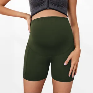 Detailed view of high-waisted dark green maternity athletic shorts for belly support.