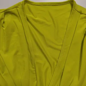 Close-up detail view of a sexy lime green solid color spring dress with v-neckline stitching