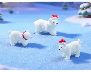 Detail view of cute Christmas polar bear figurines wearing red Santa hats on snow