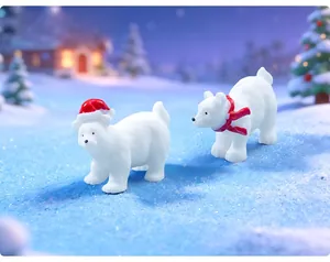 Close-up of two polar bear figurines with Santa hat and scarf in a snowy scene