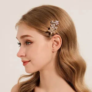 Pince à cheveux fleur en zircon doré portée par un mannequin blond vue de profil élégante