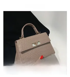 Close-up of the elegant crocodile skin texture and gold-tone twist lock on handbag