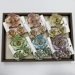 Elegant flower-shaped hair clip sets in multiple colors displayed in a wooden tray