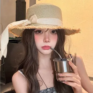 Detailed look at a stylish summer straw sun hat with a lace bow and frayed brim