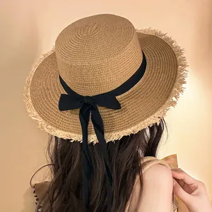 Detailed back view of a woman wearing a summer straw sun hat with black ribbon bow
