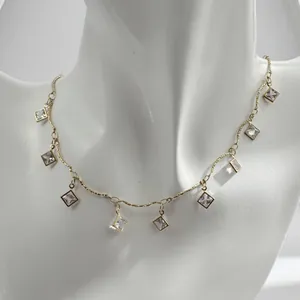 Close-up detail of a French vintage gold-tone necklace with square crystal pendants