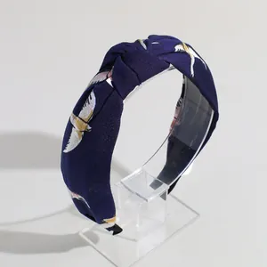 Cerchietto annodato largo in tessuto blu scuro con eleganti motivi a uccello dorato