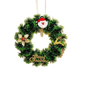 Green Christmas tinsel wreath featuring Santa Claus decor and gold Merry Christmas sign