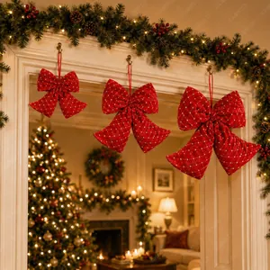 Close-up of red quilted Christmas bows hanging on a white festive mantel
