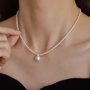 Elegant sterling silver pearl necklace with round pendant shown on female model