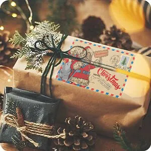 Close-up of a vintage Santa Claus greeting card attached to a kraft paper gift box.