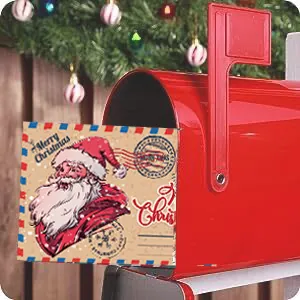 Detail view of a vintage Santa Claus Christmas greeting card placed in a red mailbox.