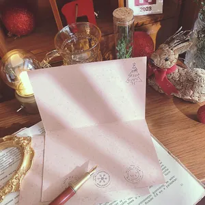 Vintage Christmas greeting card set with envelope displayed in a festive holiday scene