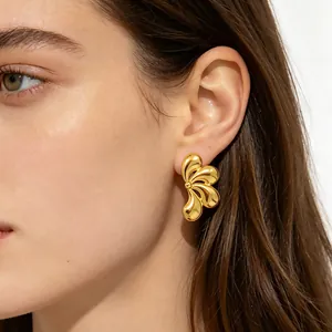 Élégantes boucles d'oreilles pétales en métal doré avec finition polie sur modèle