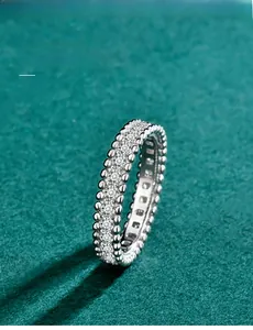Close-up view of a Moissanite eternity ring with delicate beaded edges in silver