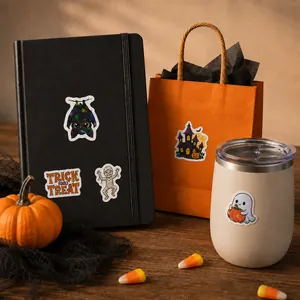 Gros plan d'autocollants vinyle d'Halloween sur un carnet et un sac cadeau en scène de fête