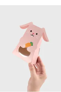 Gros plan d'une jolie boîte cadeau en papier en forme de lapin rose avec fenêtre ronde