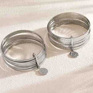 Close-up detail of the ethnic style vintage wide-faced silver bracelet set with coin pendant