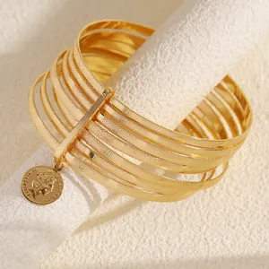 Close-up detail of 10-piece gold alloy bangle set featuring a retro coin charm