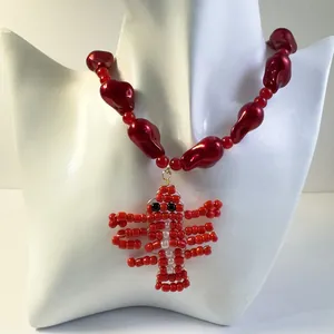 Detailed view of a unique red beaded necklace featuring a handmade lobster pendant design