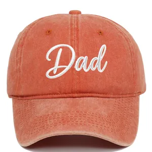 Detail shot of an orange washed cotton baseball cap with white DAD script embroidery