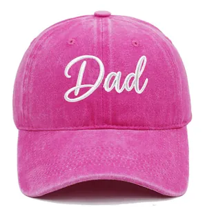 Close-up of pink washed cotton baseball cap with white cursive Dad embroidery detail