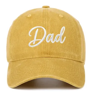 Close-up detail of white 'Dad' script embroidery on a yellow vintage washed cotton baseball cap