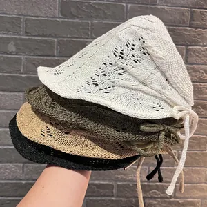 Macro detail of stacked knitted crochet bucket hats with hollow-out leaf patterns