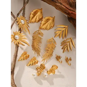 18K gold plated leaf earrings collection with pearls on natural wood background