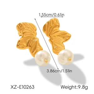 Detailed macro view of gold leaf-shaped earrings with white pearl and dimensions.