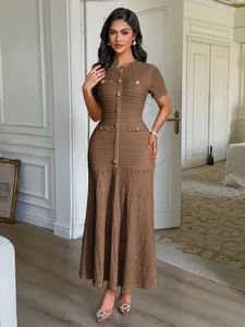 Robe longue élégante marron à manches courtes avec boutons dorés en salon intérieur