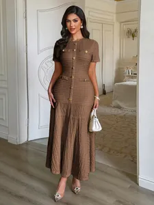 Détail d'une élégante robe longue marron boutonnée à manches courtes pour femme.