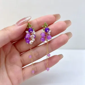 Vue détaillée des boucles d'oreilles en grappe de raisin violet avec accents de fleurs
