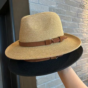 Detail of tan and black woven straw fedora hats featuring elegant leather buckles