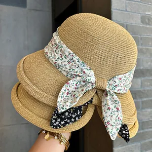 Close-up view of elegant woven straw hats featuring beautiful floral ribbon details