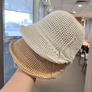 Detail shot of elegant French style woven straw sun hats for women in beige and tan