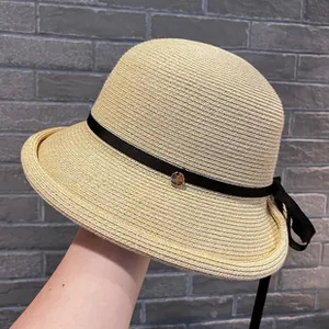 Detail view of an elegant French style woven straw sun hat with black leather strap