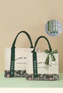 Detailed view of William Morris floral canvas tote bag with decorative green ribbon.