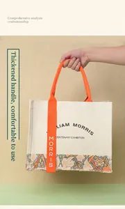 Detailed view of a William Morris canvas tote bag featuring thick orange handles