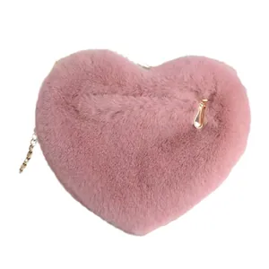 Pink heart-shaped plush crossbody bag featuring a soft faux fur texture and gold chain