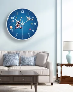 Modern silent wall clock with astronaut theme displayed in a blue-toned living room