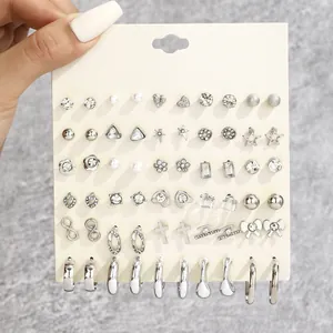 Detailed view of 30 pairs of silver-tone earrings set featuring bows and stars