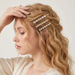 Elegant gold bobby pins set with sparkling clear rhinestones worn on wavy blonde hair