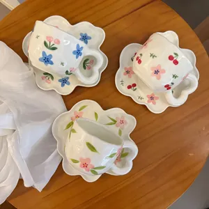 Detailed top view of ceramic coffee cups with heart handles and floral petal saucers