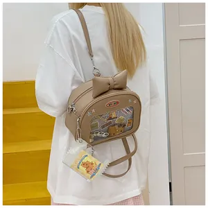 Close-up of brown PU leather Ita bag with transparent window and bow decoration
