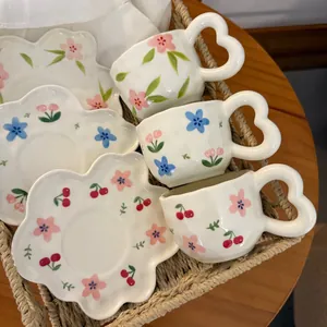 Macro detail of floral ceramic coffee cup with heart handle and wavy cloud saucer