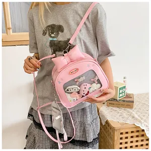 Pink Ita bag detail featuring transparent window with plush toys and ribbon bow decoration