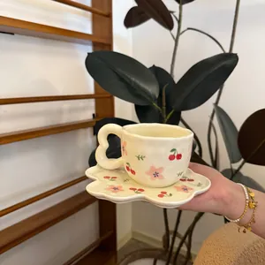 Handcrafted cream ceramic coffee cup and petal saucer set with cherry flower patterns